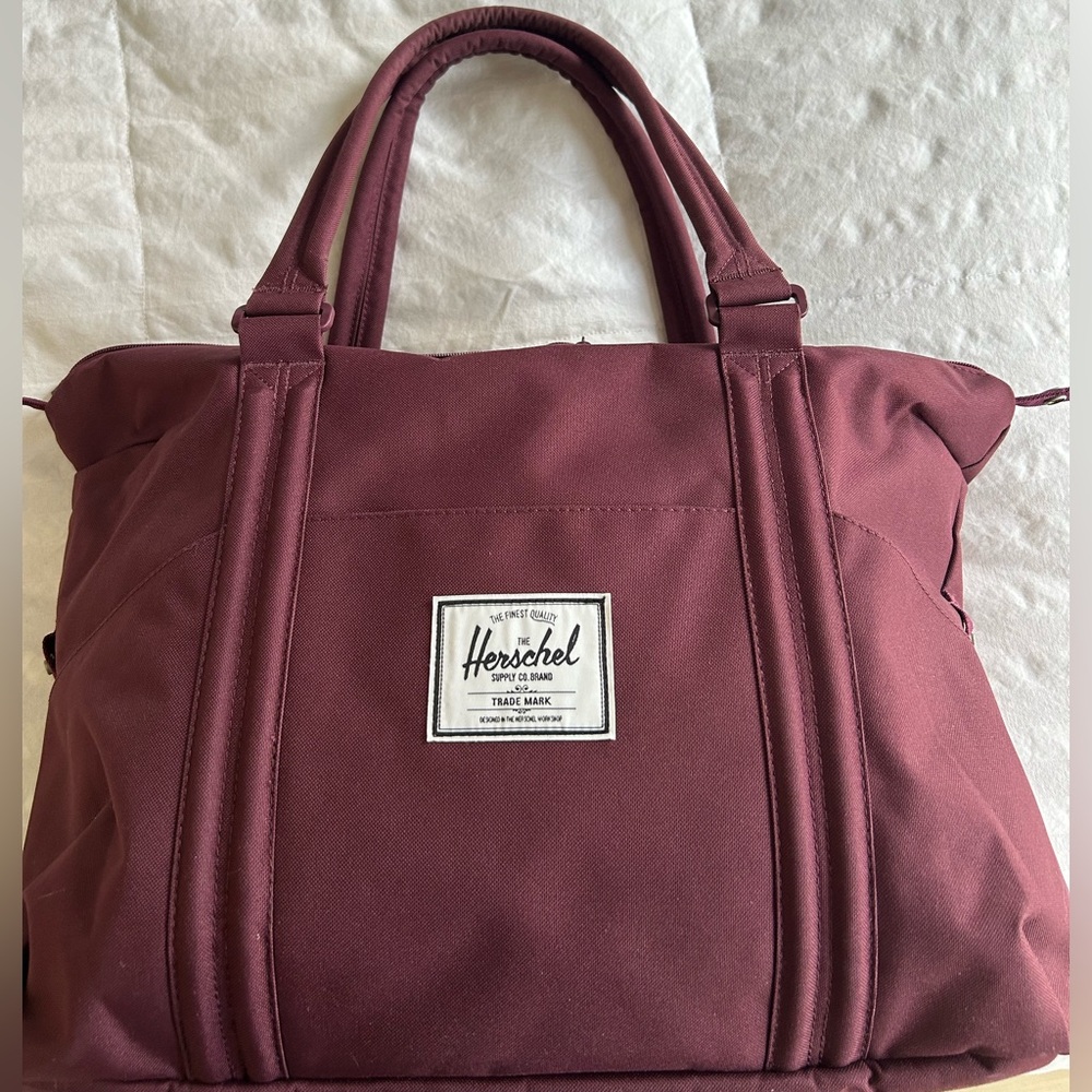 Herschel Supply Company Strand Duffel Tote Bag in a burgundy and red hue.